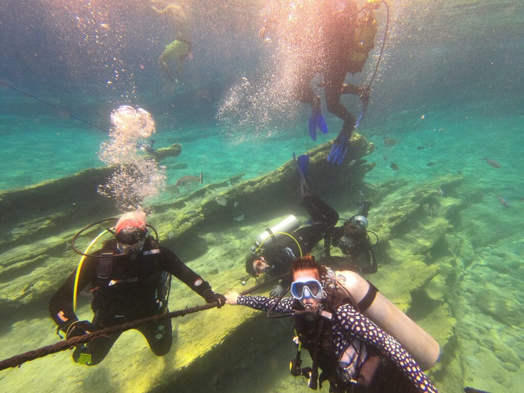man in black wet suit under water